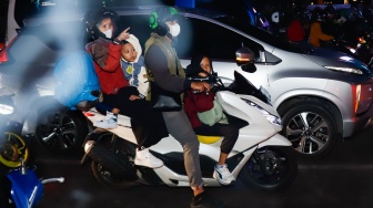 Pemudik bersepeda motor melintas di Jalan Inspeksi Kalimalang, Bekasi, Jawa Barat, Jumat (28/3/2025). [Suara.com/Alfian Winanto]
