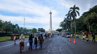 Warga berwisata di Monumen Nasional (Monas), Jakarta, Sabtu (5/4/2025). [Suara.com/Alfian Winanto]
