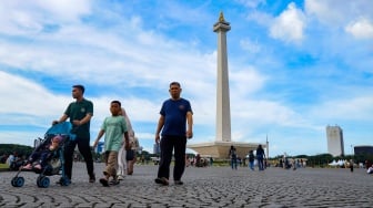 Warga berwisata di Monumen Nasional (Monas), Jakarta, Sabtu (5/4/2025). [Suara.com/Alfian Winanto]