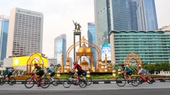 Sejumlah komunitas pesepeda melintasi kawasan Bundaran HI, Jakarta, Sabtu (19/4/2025). [Suara.com/Alfian Winanto]  