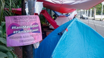 Sejumlah aktivis beraktivitas di dalam tenda dalam kegiatan Piknik Melawan di Depan Gerbang Pancasila DPR RI, Jakarta, Senin (21/4/2025). [Suara.com/Alfian Winanto]