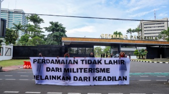 Sejumlah aktivis perempuan membentangkan spanduk tuntutan saat aksi Piknik Melawan di Depan Gerbang Pancasila DPR RI, Jakarta, Senin (21/4/2025). [Suara.com/Alfian Winanto]