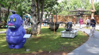 Pengunjung melihat karya instalasi seni pada Pameran Art Jakarta Gardens di Hutan Kota Plataran, Senayan, Jakarta, Jumat (25/4/2025). [Suara.com/Alfian Winanto]