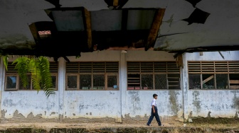 Seorang siswa berjalan di dekat ruang kelas SMP Negeri 2 Cimanuk, Pandeglang, Banten, Senin (28/4/2025). [ANTARA FOTO/Angga Budhiyanto/rwa]