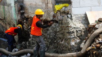 Petugas Sudin Sumber Daya Air Jakarta Utara memperbaiki tembok galangan kapal yang roboh di kawasan Pluit Penjaringan, Jakarta, Selasa (29/4/2025). [ANTARA FOTO/Fathul Habib Sholeh/nym]