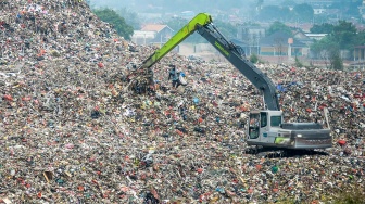 Pemulung memungut sampah di Tempat Pembuangan Akhir (TPA) Jatiwaringin, Kabupaten Tangerang, Banten, Selasa (29/4/2025). [Suara.com/Alfian Winanto]