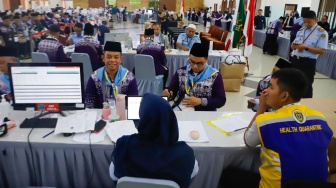 Petugas melakukan pendataan calon jamaah haji di Asrama Haji Pondok Gede, Jakarta, Senin (5/5/2025). [Suara.com/Alfian Winanto]
