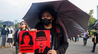 Aktivis Jaringan Solidaritas Korban untuk Keadilan membawa poster Marsinah saat mengikuti aksi Kamisan ke-860 di depan Istana Merdeka, Jakarta, Kamis (8/5/2025). [Suara.com/Alfian Winanto]