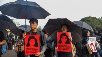 Aktivis Jaringan Solidaritas Korban untuk Keadilan membawa poster Marsinah saat mengikuti aksi Kamisan ke-860 di depan Istana Merdeka, Jakarta, Kamis (8/5/2025). [Suara.com/Alfian Winanto]