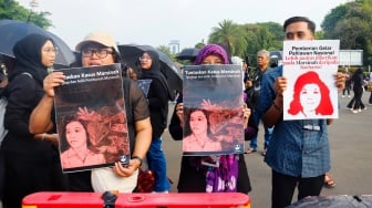 Aktivis Jaringan Solidaritas Korban untuk Keadilan membawa poster Marsinah saat mengikuti aksi Kamisan ke-860 di depan Istana Merdeka, Jakarta, Kamis (8/5/2025). [Suara.com/Alfian Winanto]