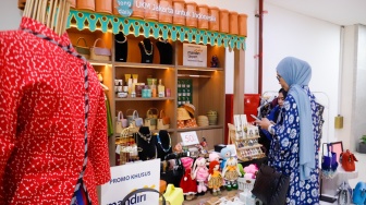 Pembeli memindai Kode Respons Cepat Standar (QRIS) di Sarinah, Jakarta, Selasa (13/5/2025). [Suara.com/Alfian Winanto]