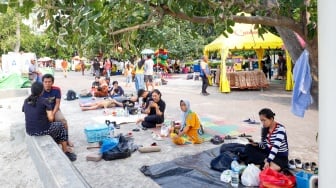 Pengunjung berwisata di Pantai Lagoon, Taman Impian Jaya Ancol, Jakarta, Selasa (13/5/2025). [Suara.com/Alfian Winanto]