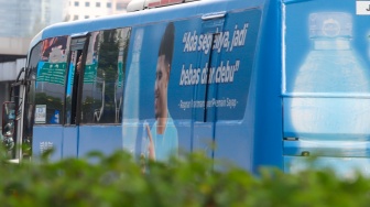 Pekerja menaiki bus Transjakarta di kawasan Jalan MH Thamrin, Jakarta, Rabu (14/5/2025). [Suara.com/Alfian Winanto]