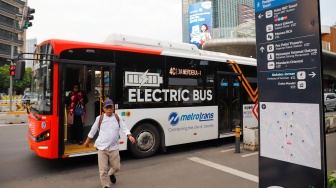 Pekerja berjalan sepulang bekerja di kawasan Jalan MH Thamrin, Jakarta, Rabu (14/5/2025). [Suara.com/Alfian Winanto]