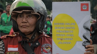Seorang pengemudi ojek daring membawa poster tuntutan saat unjuk rasa di kawasan Patung Kuda, Jakarta, Selasa (20/5/2025). [ANTARA FOTO/Jasmine Nadhya Thanaya/rwa]