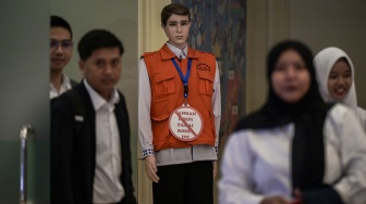 Pegawai Kementerian Ketenagakerjaan melintas di samping sebuah maneken saat jam pulang kerja di Kantor Kementerian Ketenagakerjaan, Jakarta, Selasa (20/5/2025). [ANTARA FOTO/Fauzan/nym]
