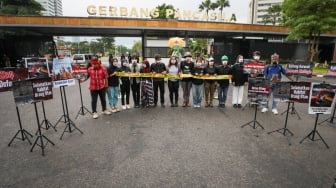 Sejumlah aktivis lingkungan menggelar aksi demonstrasi di Kompleks Parlemen DPR RI, Senayan, Jakarta, Jumat (23/5/2025). [Suara.com/Alfian Winanto]
