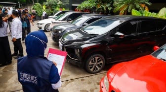 Petugas memeriksa kendaraan yang menjadi barang sitaan di Gedung Merah Putih Komisi Pemberantasan Korupsi (KPK), Jakarta, Senin (26/5/2025). [Suara.com/Alfian Winanto] 