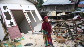 Warga berdiri di depan rumahnya yang rusak akibat tanah amblas di kawasan jalan Poros Samarinda-Balikpapan di Desa Batuah, Loa Janan, Kabupaten Kutai Kartanegara, Kalimantan Timur, Minggu (25/5/2025). [ANTARA FOTO/M Risyal Hidayat/YU]
