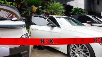Petugas memeriksa kendaraan yang menjadi barang sitaan di Gedung Merah Putih Komisi Pemberantasan Korupsi (KPK), Jakarta, Senin (26/5/2025). [Suara.com/Alfian Winanto] 