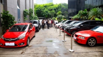 Petugas memeriksa kendaraan yang menjadi barang sitaan di Gedung Merah Putih Komisi Pemberantasan Korupsi (KPK), Jakarta, Senin (26/5/2025). [Suara.com/Alfian Winanto] 