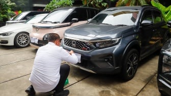 Petugas memeriksa kendaraan yang menjadi barang sitaan di Gedung Merah Putih Komisi Pemberantasan Korupsi (KPK), Jakarta, Senin (26/5/2025). [Suara.com/Alfian Winanto] 