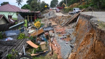 Pengendara mobil melintasi jalan yang amblas di jalan Poros Samarinda-Balikpapan di Desa Batuah, Loa Janan, Kabupaten Kutai Kartanegara, Kalimantan Timur, Minggu (25/5/2025). [ANTARA FOTO/M Risyal Hidayat/YU]