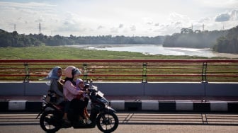 Pengendara melintasi jembatan di atas aliran sungai Citarum yang dipenuhi sampah dan eceng gondok di Batujajar, Kabupaten Bandung Barat, Jawa Barat, Selasa (27/5/2025). [ANTARA FOTO/Abdan Syakura/bar]