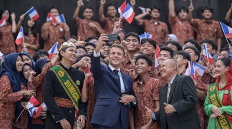 PPresiden Prancis Emmanuel Macron (tengah) didampingi Rektor Universitas Negeri Jakarta (UNJ) Komarudin (keempat kanan) berswafoto bersama pelajar setibanya di UNJ, Jakarta, Rabu (28/5/2025). [ANTARA FOTO/Fauzan/rwa]