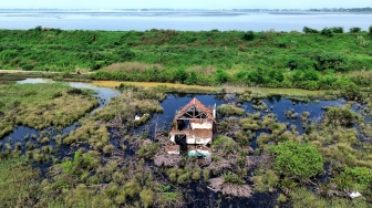 Foto udara sebuah rumah rusak di pinggir kolam penampungan semburan lumpur Lapindo di Porong, Sidoarjo, Jawa Timur, Kamis (29/5/2025). [ANTARA FOTO/Umarul Faruq/rwa]