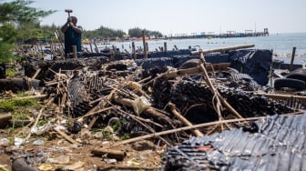 Warga mengumpulkan sampah plastik di pantai Balongan Indah, Indramayu, Jawa Barat, Jumat (30/5/2025). [ANTARA FOTO/Dedhez Anggara/bar]