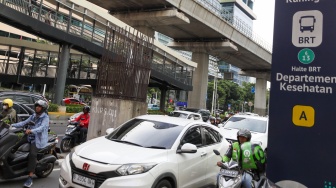 Pengendara melintas di dekat tiang bekas proyek monorel Jakarta di kawasan Jalan HR Rasuna Said, Jakarta, Senin (2/6/2025). [Suara.com/Alfian Winanto]