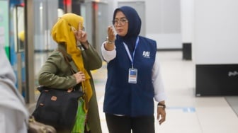 Pekerja lanjut usia (lansia) menyapa pengguna MRT Jakarta di Stasiun Bundaran HI, Jakarta, Selasa (3/6/2025). [Suara.com/Alfian Winanto]