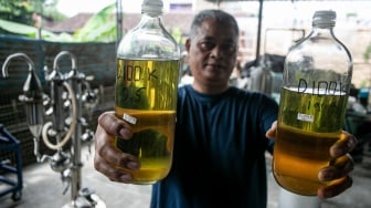 Warga Arif Surono menunjukkan BBM alternatif yang dihasilkan dari sampah plastik dengan alat pirolisi tabung bertingkat Pitara di rumahnya Desa Gumpang, Kartasura, Sukoharjo, Jawa Tengah, Senin (2/6/2025). [ANTARA FOTO/Mohammad Ayudha/foc]