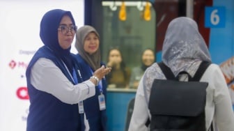 Pekerja lanjut usia (lansia) menyapa pengguna MRT Jakarta di Stasiun Bundaran HI, Jakarta, Selasa (3/6/2025). [Suara.com/Alfian Winanto]