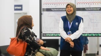 Pekerja lanjut usia (lansia) menyapa pengguna MRT Jakarta di Stasiun Bundaran HI, Jakarta, Selasa (3/6/2025). [Suara.com/Alfian Winanto]
