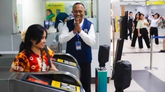 Pekerja lanjut usia (lansia) menyapa pengguna MRT Jakarta di Stasiun Bundaran HI, Jakarta, Selasa (3/6/2025). [Suara.com/Alfian Winanto]