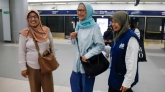 Pekerja lanjut usia (lansia) menyapa pengguna MRT Jakarta di Stasiun Bundaran HI, Jakarta, Selasa (3/6/2025). [Suara.com/Alfian Winanto]