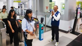 Pekerja lanjut usia (lansia) menyapa pengguna MRT Jakarta di Stasiun Bundaran HI, Jakarta, Selasa (3/6/2025). [Suara.com/Alfian Winanto]