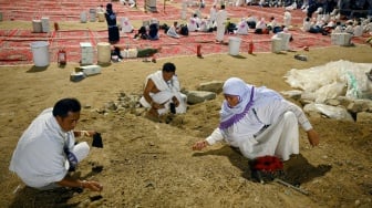 Jamaah haji Indonesia mengumpulkan batu kerikil saat mabit di Muzdalifah, Makkah, Arab Saudi, Kamis (5/6/2025) malam. [ANTARA FOTO/Andika Wahyu/foc]