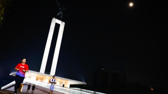 Warga beraktivitas saat malam hari di Taman Lapangan Banteng, Jakarta, Senin (9/6/2025). [Suara.com/Alfian Winanto]