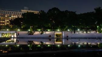 Warga beraktivitas saat malam hari di Taman Lapangan Banteng, Jakarta, Senin (9/6/2025). [Suara.com/Alfian Winanto]
