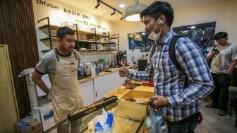 Pekerja yang juga penyandang disabilitas melayani pelanggan di Kopi Difabis, Terowongan Kendal, Jakarta, (9/6/2025). [Suara.com/Alfian Winanto]