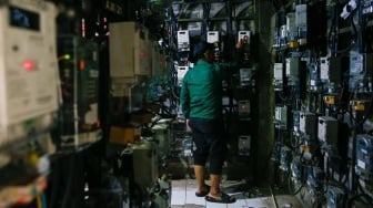 Petugas mengecek meteran listrik di Rusun Bendungan Hilir, Jakarta, Selasa (10/6/2025). [Suara.com/Alfian Winanto]