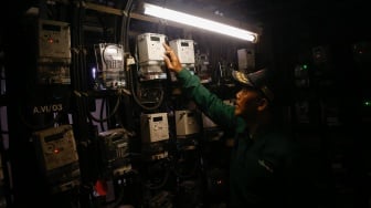 Petugas mengecek meteran listrik di Rusun Bendungan Hilir, Jakarta, Selasa (10/6/2025). [Suara.com/Alfian Winanto]