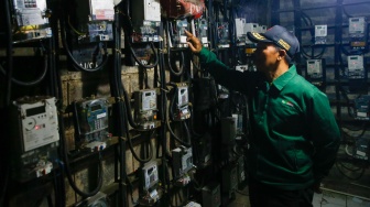 Petugas mengecek meteran listrik di Rusun Bendungan Hilir, Jakarta, Selasa (10/6/2025). [Suara.com/Alfian Winanto]