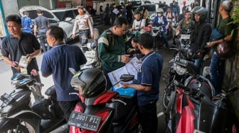 Petugas melakukan cek fisik kendaraan milik warga untuk pembayaran pajak kendaraan bermotor di Gedung Layanan Satu Atap Polda Metro Jaya, Jakarta, Senin (16/6/2025). [ANTARA FOTO/Sulthony Hasanuddin/tom]