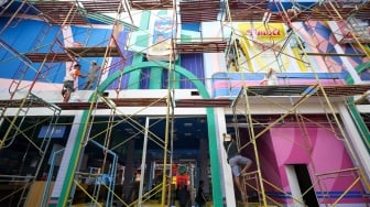 Pekerja menyelesaikan pembuatan gerai yang akan berpartisipasi dalam Jakarta Fair 2025 di JIExpo, Kemayoran, Jakarta, Rabu (18/6/2025). [Suara.com/Alfian Winanto]