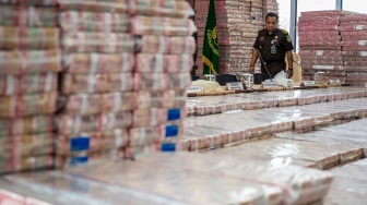 Petugas merapikan barang bukti uang sitaan saat konferensi pers kasus korupsi ekspor crude palm oil (CPO) di Gedung Bundar Jampidus Kejaksaaan Agung (Kejagung), Jakarta, Selasa (17/6/2025). [ANTARA FOTO/Bayu Pratama S/bar]