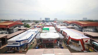 Pekerja menyelesaikan pembuatan gerai yang akan berpartisipasi dalam Jakarta Fair 2025 di JIExpo, Kemayoran, Jakarta, Rabu (18/6/2025). [Suara.com/Alfian Winanto]